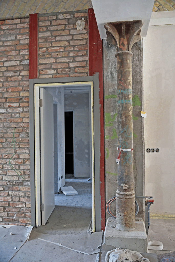 Detail: Erhaltene gusseiserne Säule und Ziegelmauerwerk in einer Erdgeschosswohnung.