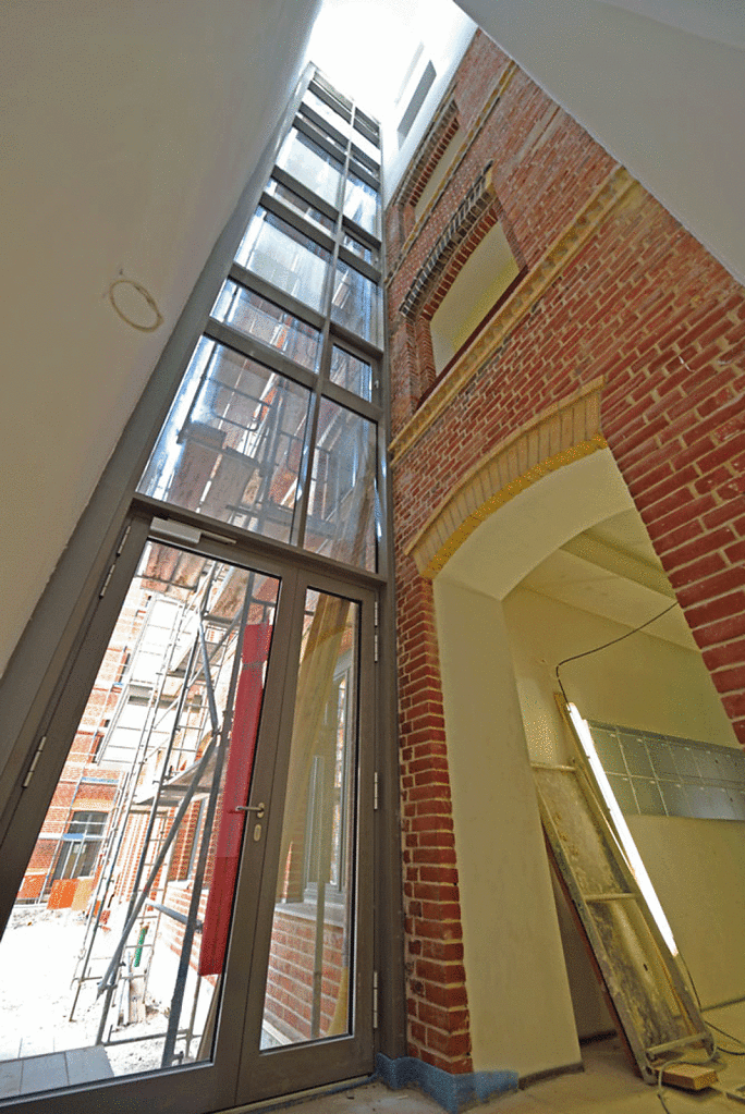 Der Übergang zwischen alter Fabrik und neuem Gebäudeflügel wurde durch ein gebäudehohes, lichtschachtartigen Treppenhaus gelöst.